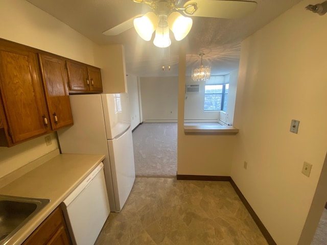 kitchen with an AC wall unit, sink, hanging light fixtures, light carpet, and white appliances