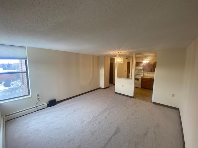 carpeted spare room with a notable chandelier, a baseboard radiator, and a textured ceiling