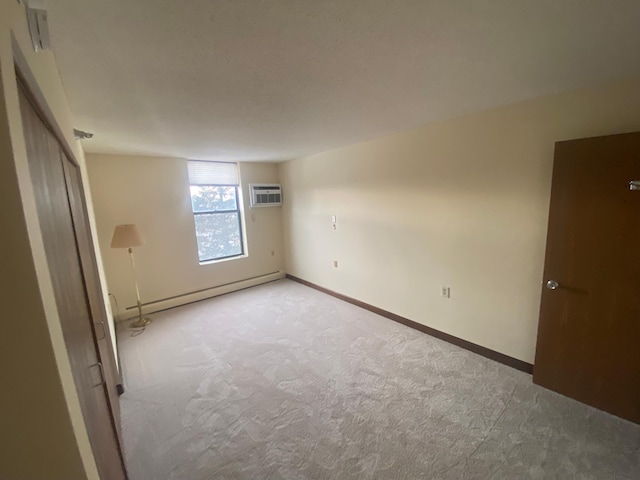 spare room featuring light carpet, a wall mounted AC, and baseboard heating