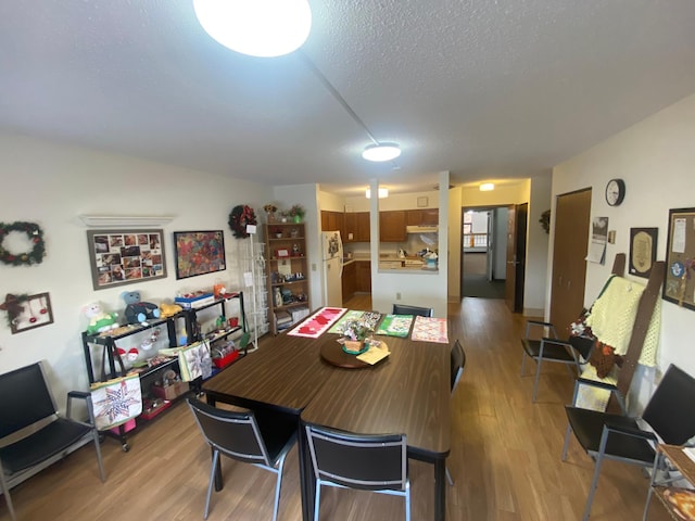 dining room featuring light hardwood / wood-style flooring and a textured ceiling