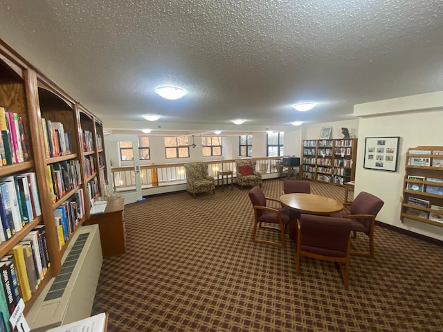 carpeted dining area with a textured ceiling