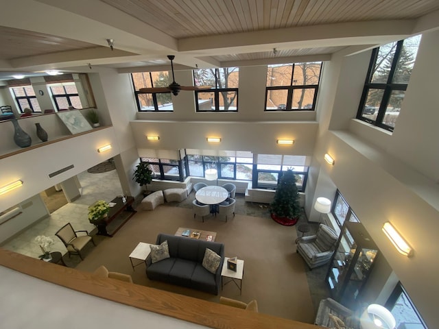 living room featuring ceiling fan, wood ceiling, and beamed ceiling