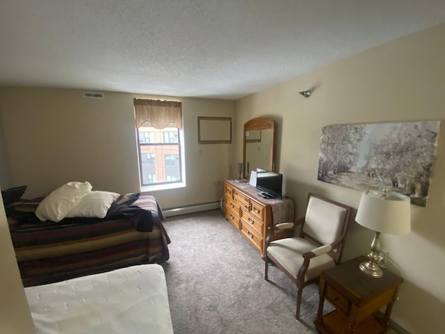 carpeted bedroom with a baseboard radiator and a textured ceiling