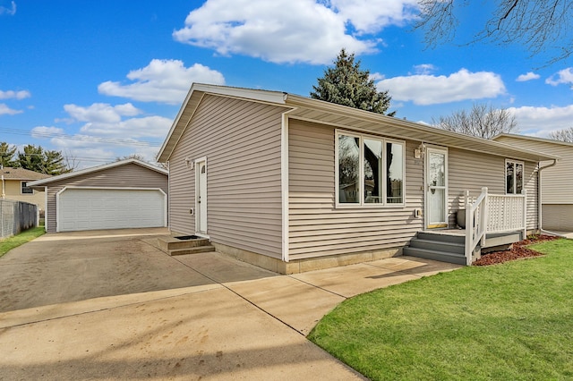 view of front of home with an outbuilding, a detached garage, and a front lawn
