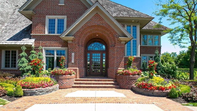 view of exterior entry with french doors and brick siding