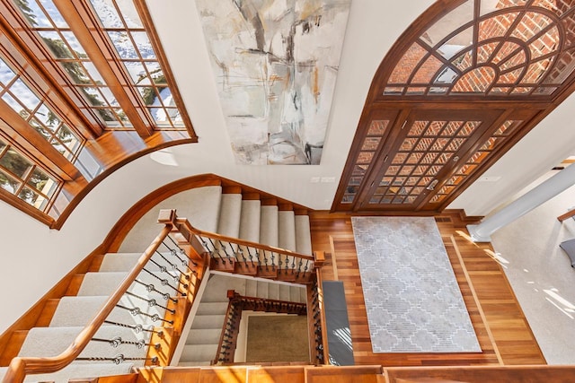 foyer with stairs, plenty of natural light, and wood finished floors