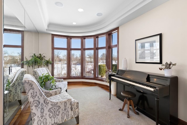 sitting room with baseboards, ornamental molding, a raised ceiling, and recessed lighting