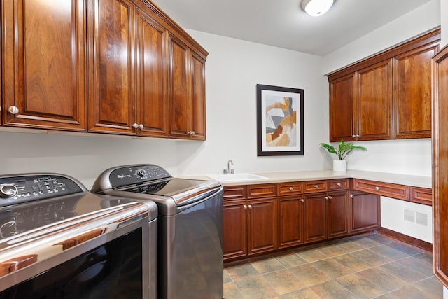 laundry area featuring cabinet space, visible vents, a sink, and independent washer and dryer