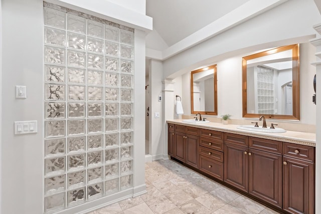 bathroom with double vanity, a sink, baseboards, and walk in shower