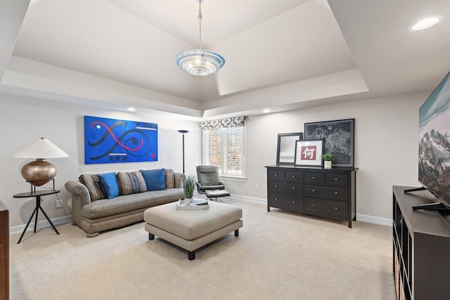 living area with recessed lighting, baseboards, a tray ceiling, and light colored carpet