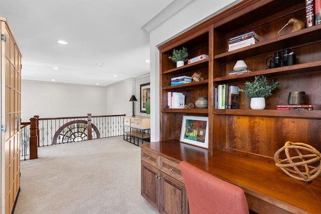 home office with ornamental molding, built in desk, recessed lighting, and light colored carpet