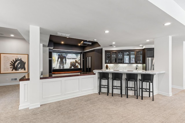 interior space featuring recessed lighting, light colored carpet, visible vents, wet bar, and stainless steel fridge