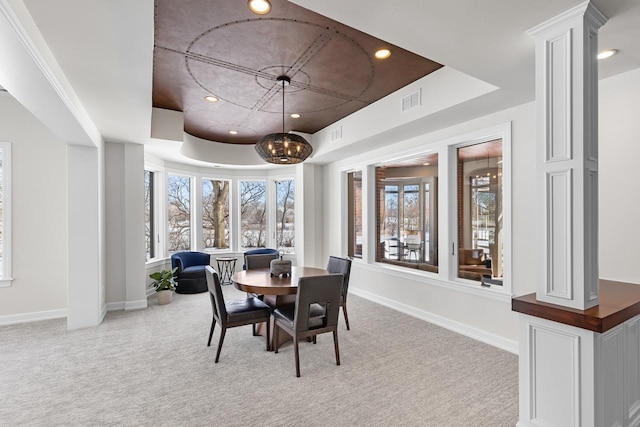 dining area with light colored carpet, visible vents, baseboards, a raised ceiling, and decorative columns