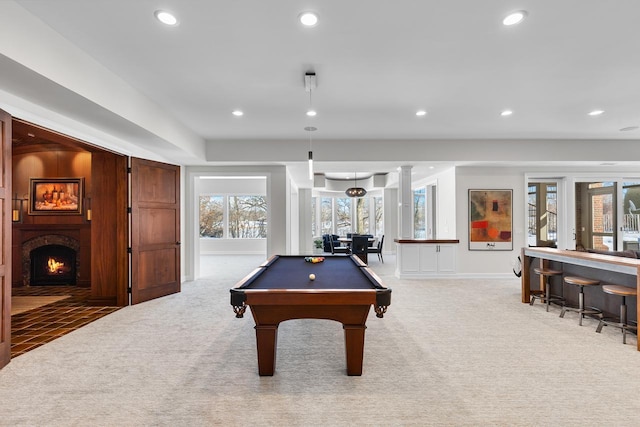 rec room featuring a warm lit fireplace, billiards, indoor bar, light colored carpet, and recessed lighting