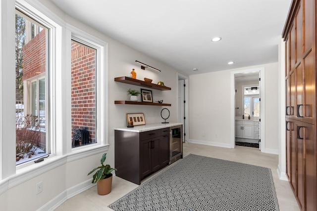 bar featuring baseboards, beverage cooler, and recessed lighting