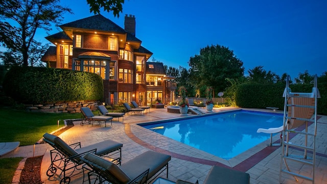 view of pool featuring a fenced in pool, a patio, fence, and a diving board