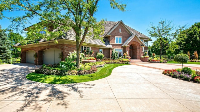 view of front of property featuring a garage, brick siding, and driveway