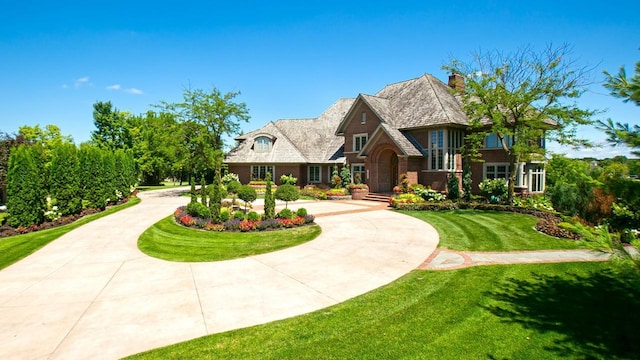 view of front facade with a front lawn and curved driveway