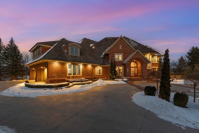 view of front of home with concrete driveway, brick siding, and french doors