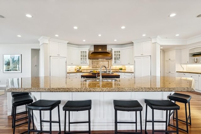 kitchen featuring a sink, dark wood-type flooring, backsplash, and custom range hood