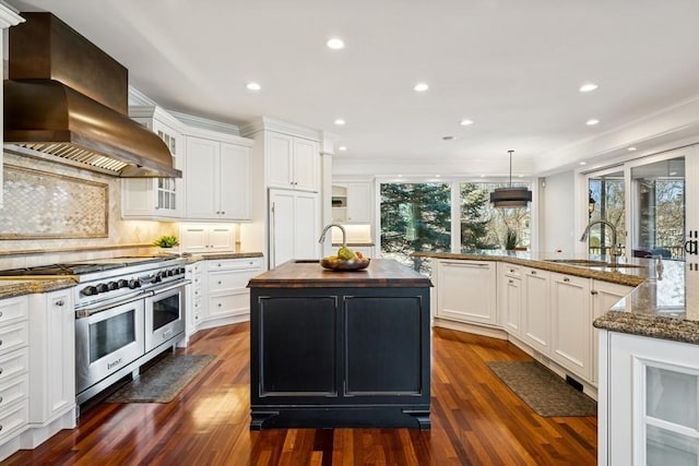 kitchen with dark wood-style flooring, white cabinets, double oven range, a center island with sink, and custom range hood