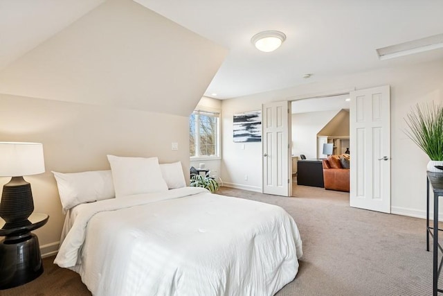 carpeted bedroom with attic access, lofted ceiling, and baseboards