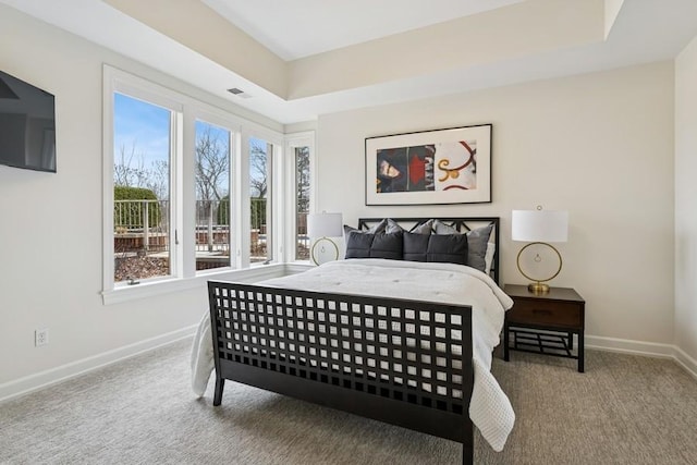 bedroom featuring carpet floors, visible vents, baseboards, and a tray ceiling