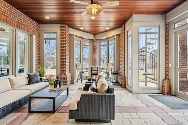 sunroom featuring wooden ceiling, a healthy amount of sunlight, and ceiling fan