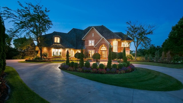 view of front of property with brick siding and curved driveway