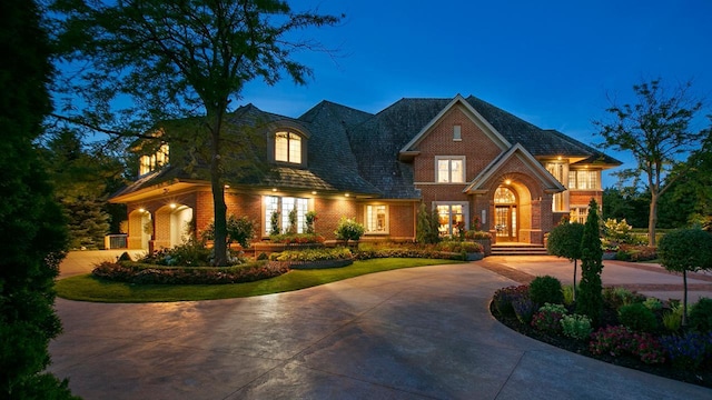 view of front facade with brick siding and curved driveway