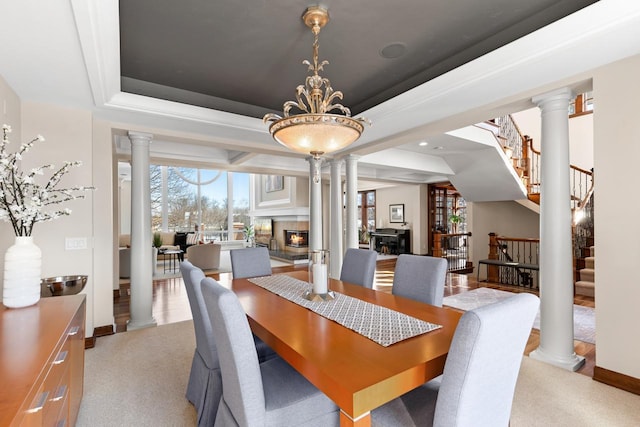 18313 Nicklaus Way, Eden Prairie, MN 55347 - dining room featuring a glass covered fireplace, stairway, decorative columns, light carpet, and baseboards