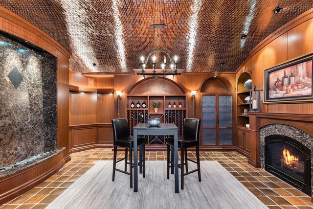 18313 Nicklaus Way, Eden Prairie, MN 55347 - wine cellar featuring built in shelves, tile patterned floors, ornamental molding, a fireplace, and a chandelier