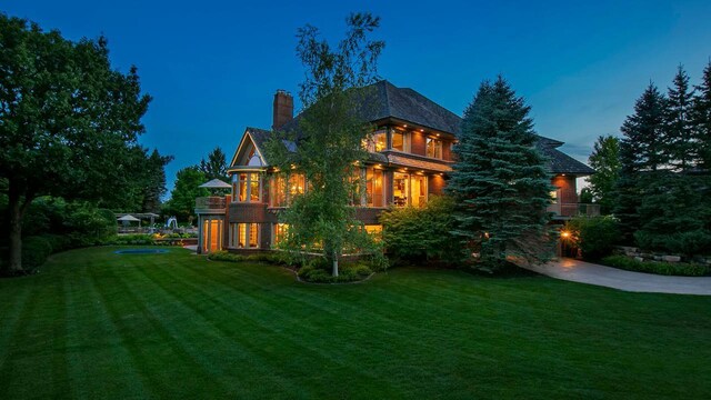 18313 Nicklaus Way, Eden Prairie, MN 55347 - rear view of house featuring a chimney, a balcony, and a lawn