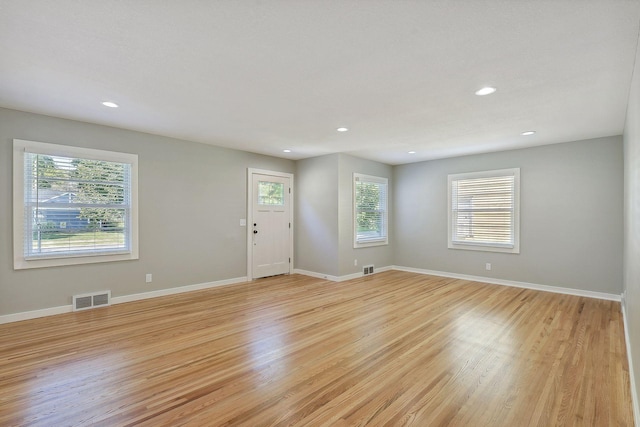 empty room with light wood-type flooring, visible vents, baseboards, and recessed lighting