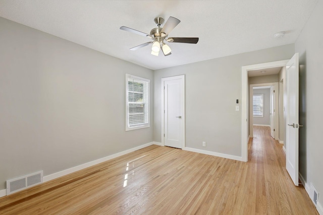 unfurnished bedroom with light wood-type flooring, visible vents, ceiling fan, and baseboards