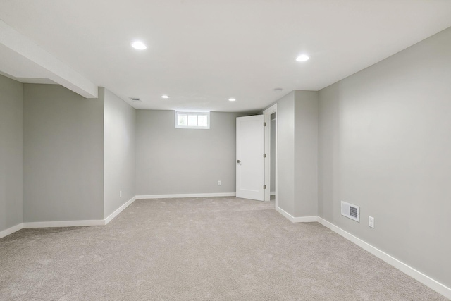 below grade area with light colored carpet, recessed lighting, visible vents, and baseboards