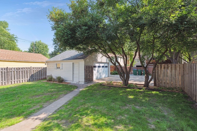 view of yard featuring a garage, an outdoor structure, and a fenced backyard