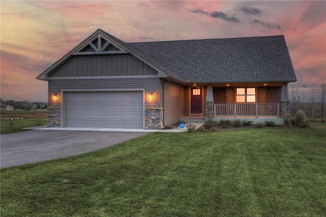 view of front of home featuring a garage, a lawn, and covered porch