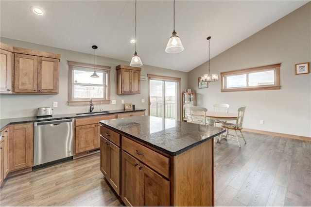 kitchen featuring a healthy amount of sunlight, sink, stainless steel dishwasher, and decorative light fixtures