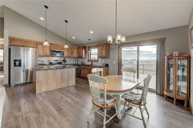 dining area featuring dark hardwood / wood-style flooring, sink, a notable chandelier, and high vaulted ceiling