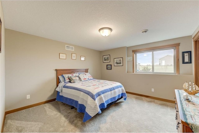 bedroom featuring light colored carpet and a textured ceiling