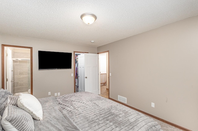 14371 Embry Path, Apple Valley, MN 55124 - bedroom with a textured ceiling, a walk in closet, baseboards, and ensuite bath