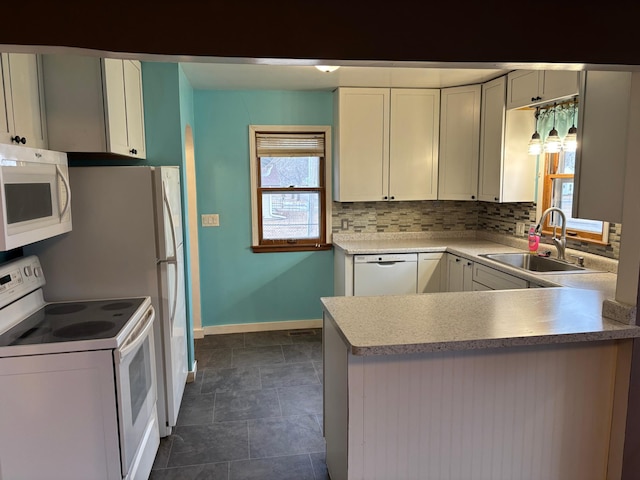 kitchen featuring sink, white appliances, tasteful backsplash, white cabinets, and kitchen peninsula