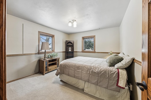 bedroom featuring multiple windows and light carpet