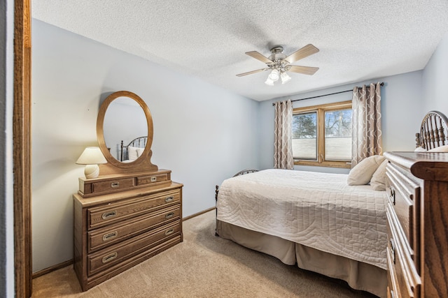 bedroom with ceiling fan, light carpet, and a textured ceiling