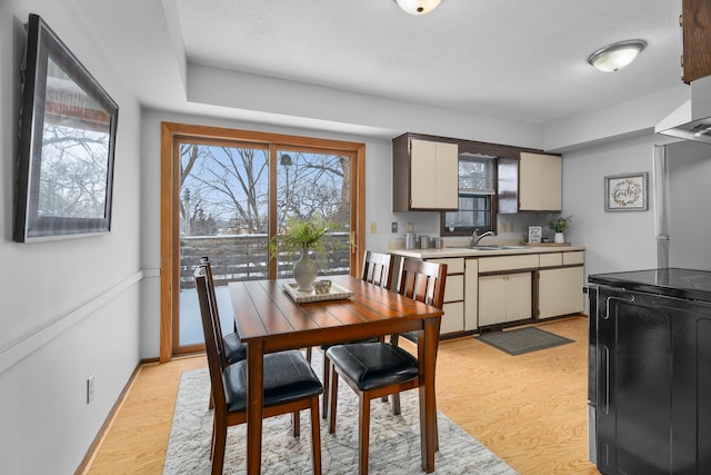 dining room featuring light wood-style flooring and baseboards