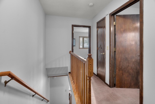 corridor featuring light carpet and an upstairs landing