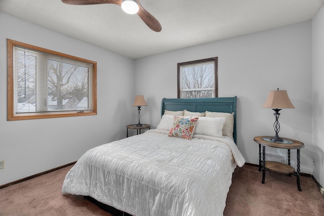 carpeted bedroom featuring multiple windows, a ceiling fan, and baseboards