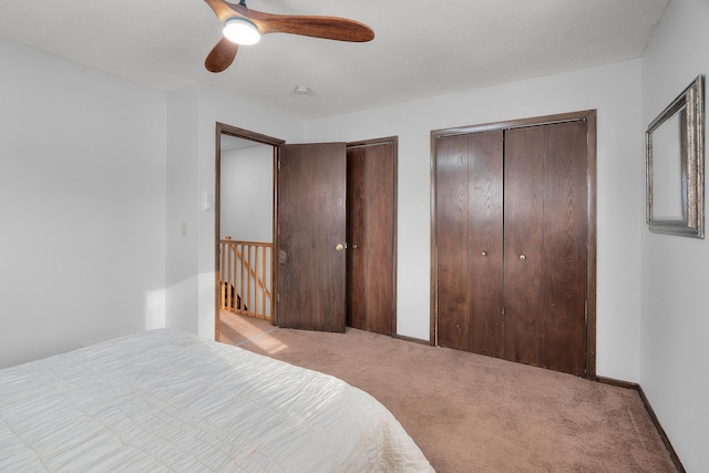 bedroom featuring carpet, two closets, a ceiling fan, and baseboards