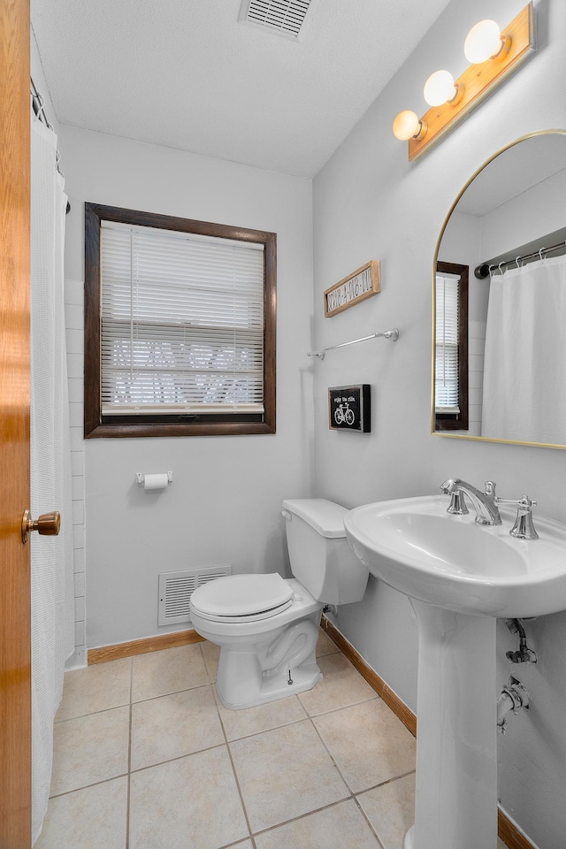 full bath featuring baseboards, visible vents, toilet, and tile patterned floors